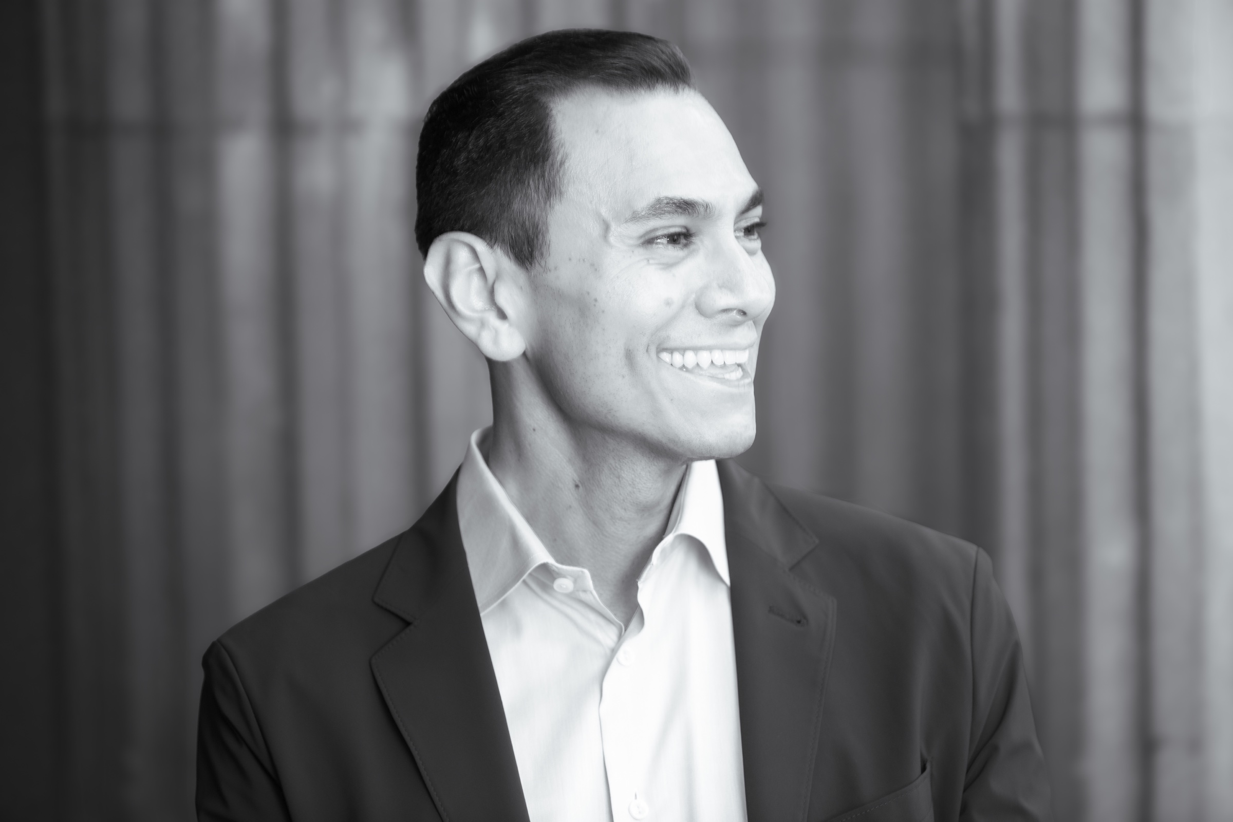 Dr. Edgar Montes smiling in a black-and-white portrait